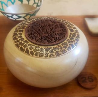 Photo of a light coloured spherical box with dark timber accents